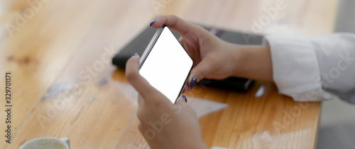 Side view of female university student using horizontal mock-up smartphone