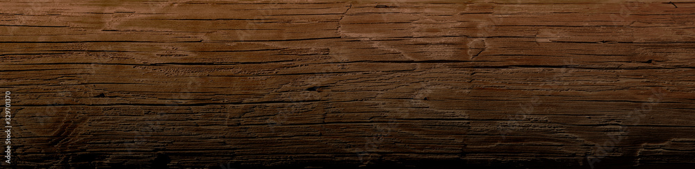 Dark stained reclaimed wood surface with aged boards lined up. Wooden floor planks with grain and texture.