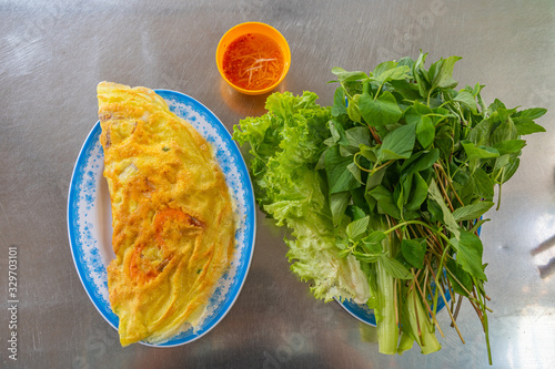 Plate of delicious Vietnamese prawn crepe served with vegetables photo