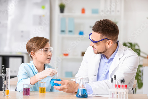 Teacher and pupil at chemistry lesson in classroom