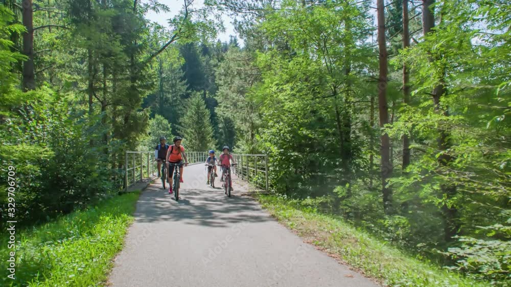 Active family of four cycling in nature Slovenia, tracking real-time Active family of four cycling in nature Slovenia, tracking real-time