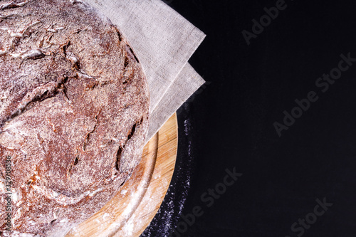 Top view of fresh soft homemade rye bread. Close-up. Delicious low carb round bread just from the bakery on wooden board. Copy space. photo