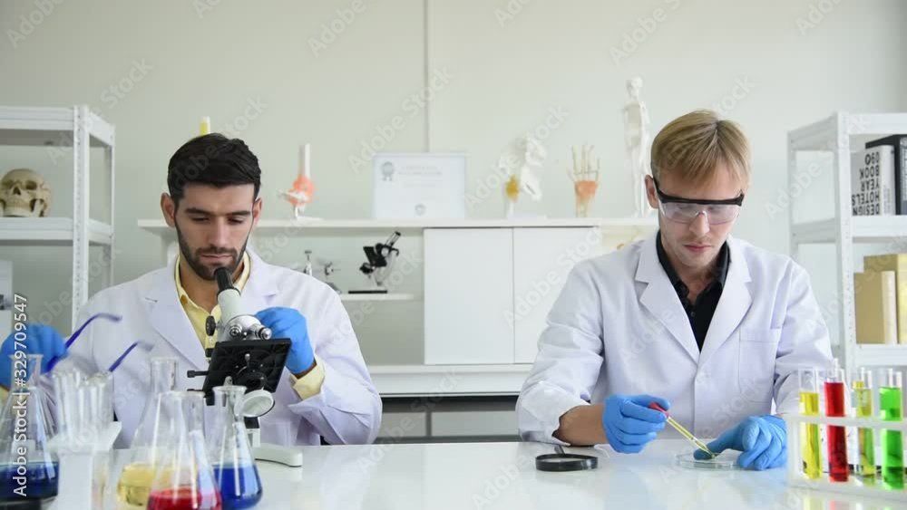 Scientist team working and research sample test with protection equipment and glasses in laboratory room Scientist team working and research sample test with protection equipment and glasses in laboratory room