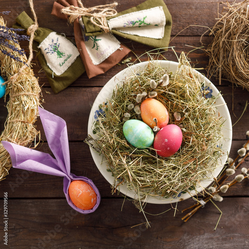 Still life of easter eggs in a bird's nest on a wooden background. Rustic. Decoration of natural. Easter celebration concept. Copy space. Flat lay. Square.