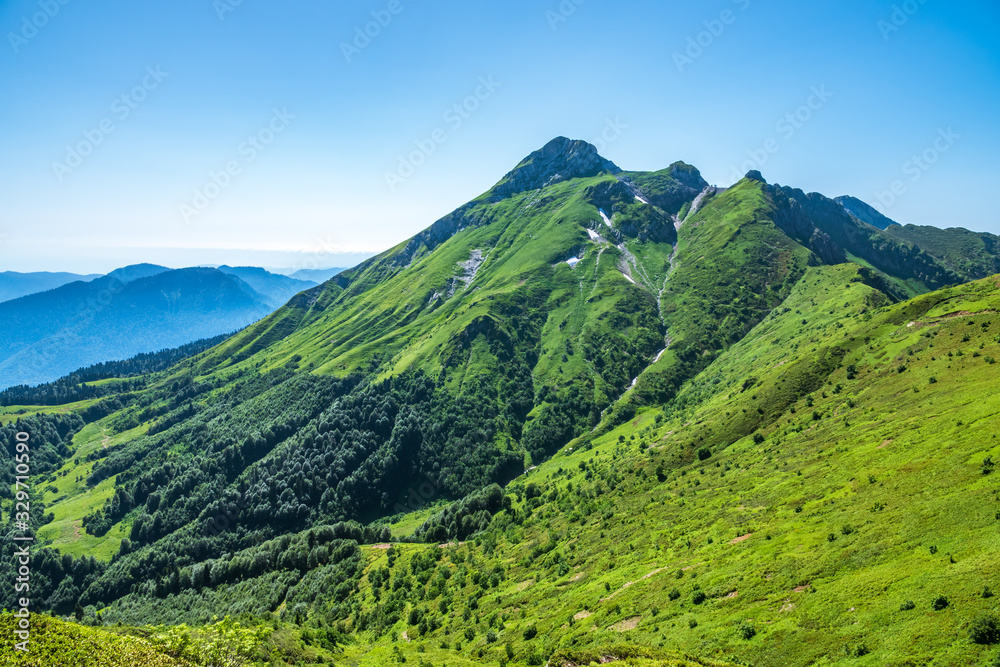 High mountain with green slope.