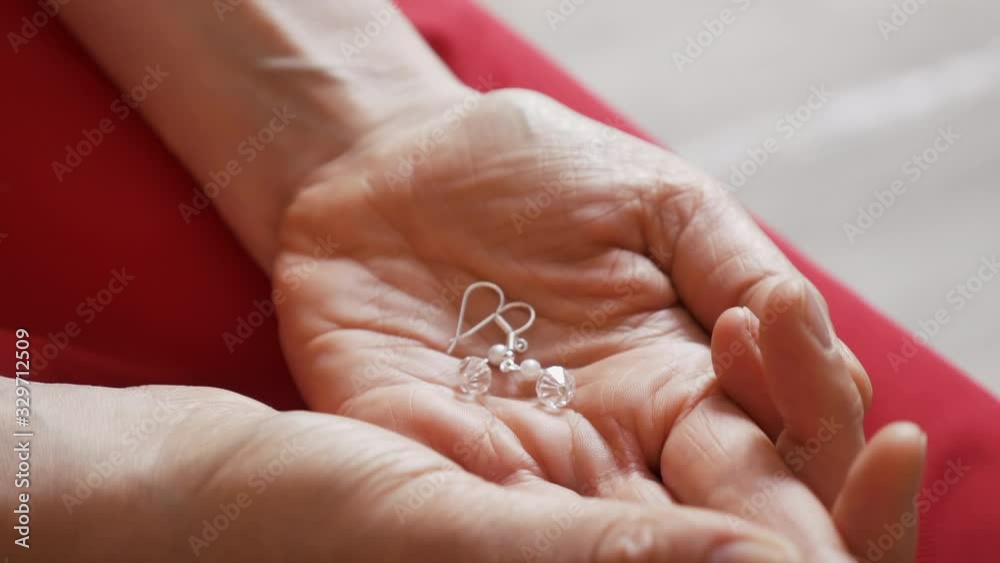 bride holds her earrings on wedding day bride holds her earrings on wedding day