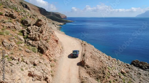 Aerial view of car driving on a mud road view of the rocky mountain range and seashore Kaliviani, Kissamos Province, Greece photo