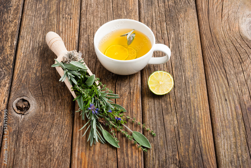 cup of herbal tea and sage, lavender, thyme, iceland lichen herb leaves on scoop