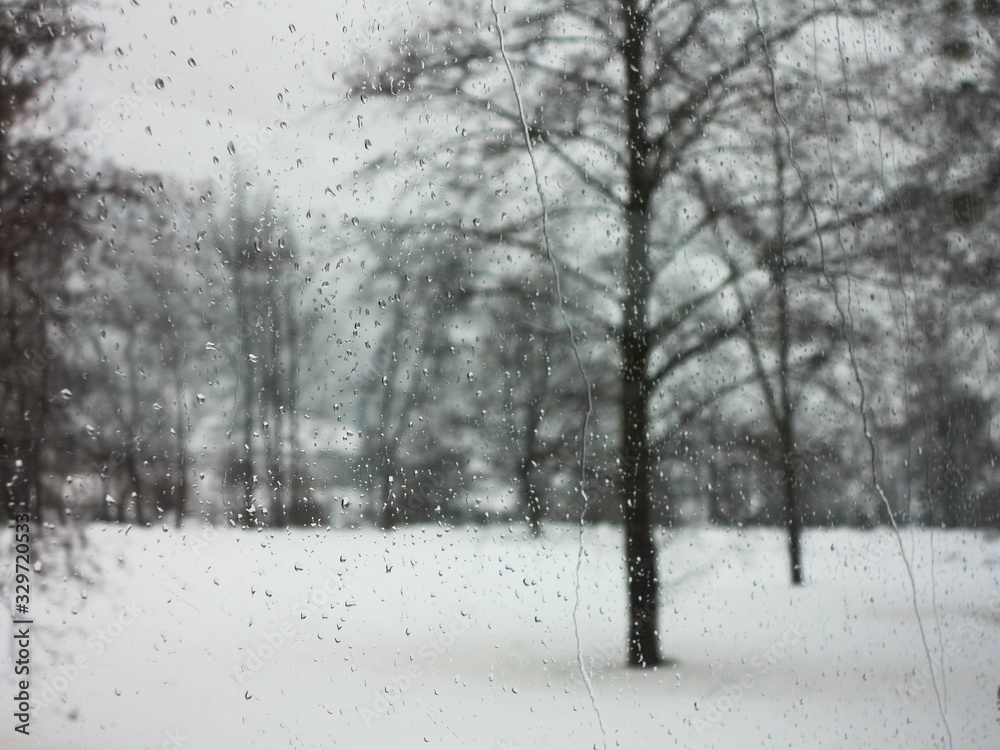 Raindrops on window with the picturesque winter landscape. Raindrops on window with the picturesque winter landscape.