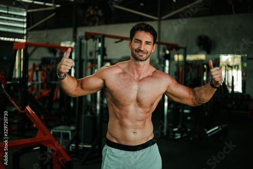 Handsome Man exercise in gym body-building with muscular strong body