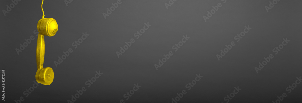 a old gold tube hanging on a wire on a gray background a old gold tube hanging on a wire on a gray background