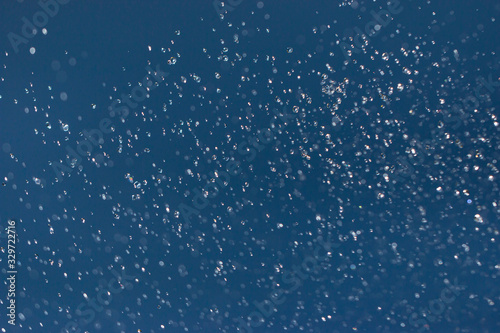 clear and fuzzy drops of water on a blue background