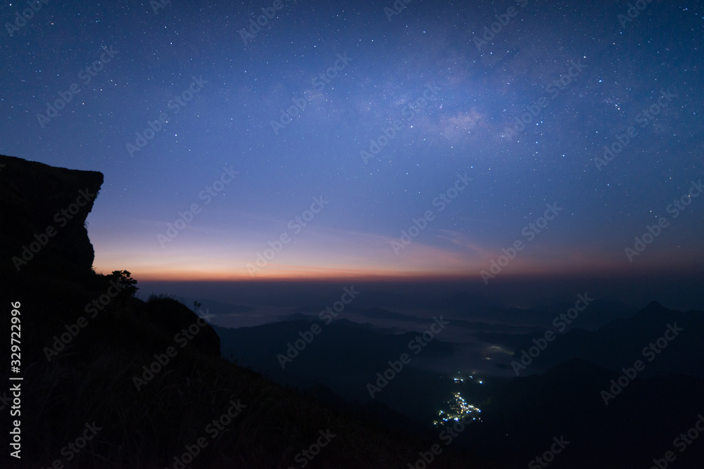 The scenery of the Milky Way over Phu Chi Fa with Zodiac light at dawn before sunrise in Chiang Rai, Thailand.