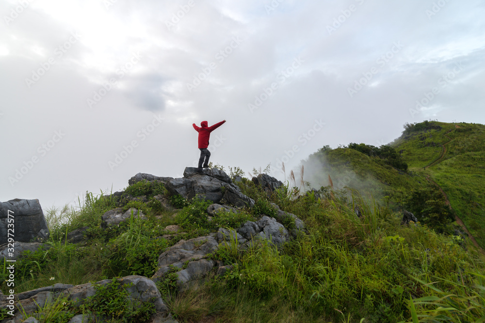 View of a man stand on the top of the peak of Pha Tang in Chiang Rai, Thailand.