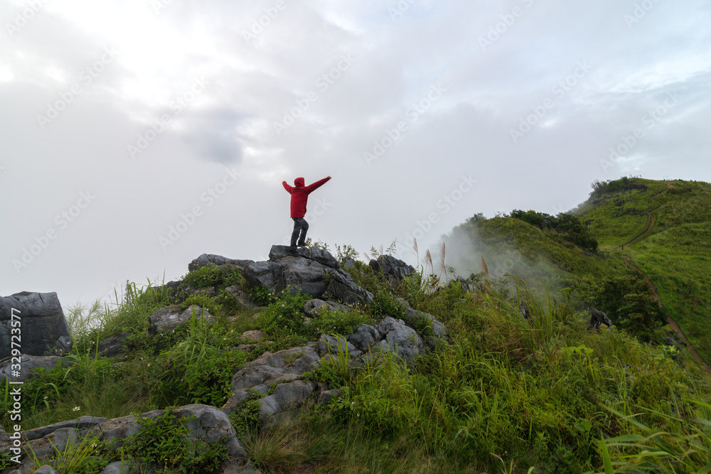 Fototapeta premium View of a man stand on the top of the peak of Pha Tang in Chiang Rai, Thailand.