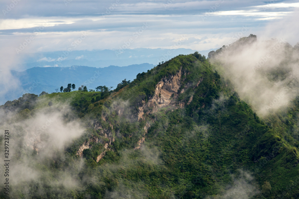 Beautiful view of clouds over the green mountain peak from Pha Tang view point in Chiang Rai, Thailand.