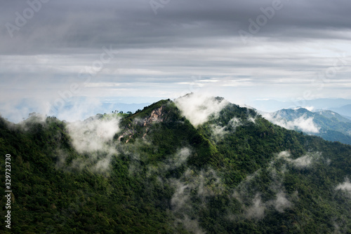 Beautiful view of clouds over the green mountain peak from Pha Tang view point in Chiang Rai, Thailand.