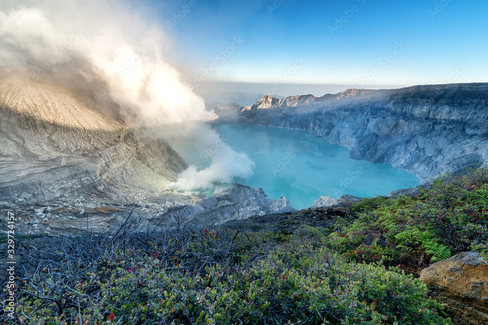 Beautiful panorama view of Kawah Ijen with green fern foreground at dawn in Java island, Indonesia.