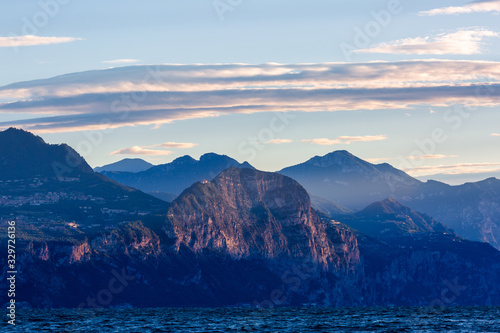 Beautiful summer morning on Garda lake with mountains on background  Italy