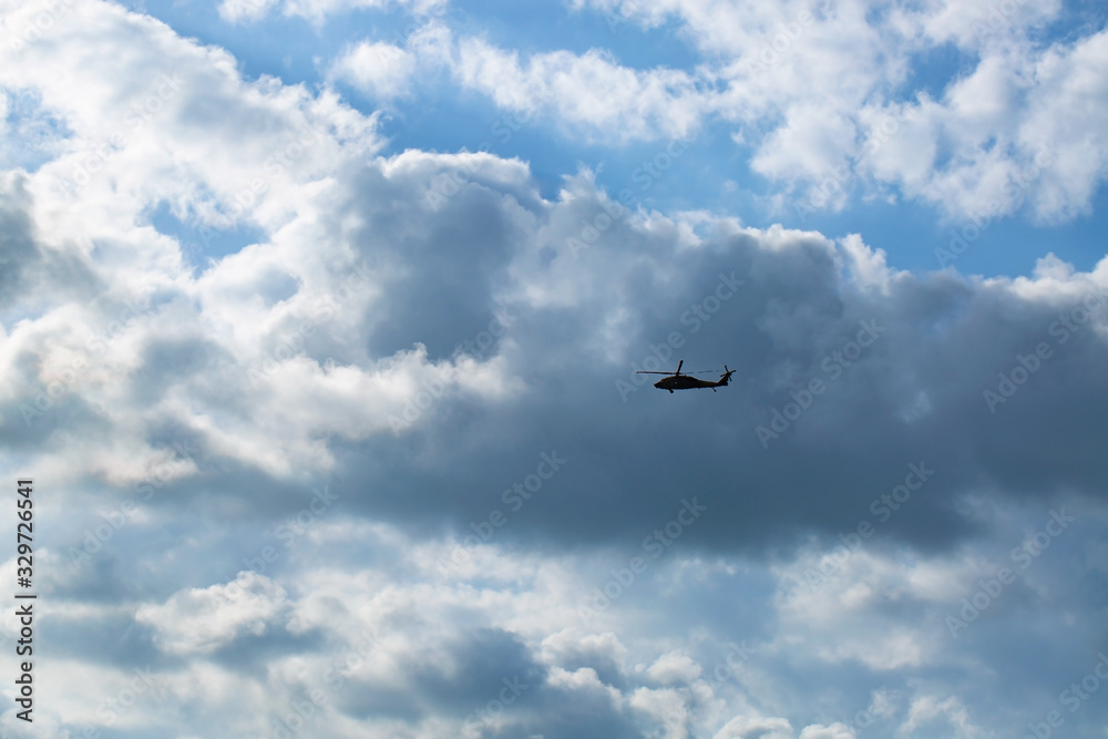 The military helicopter flying in sky with clouds