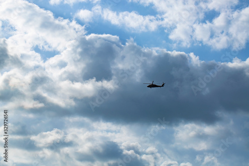 The military helicopter flying in sky with clouds