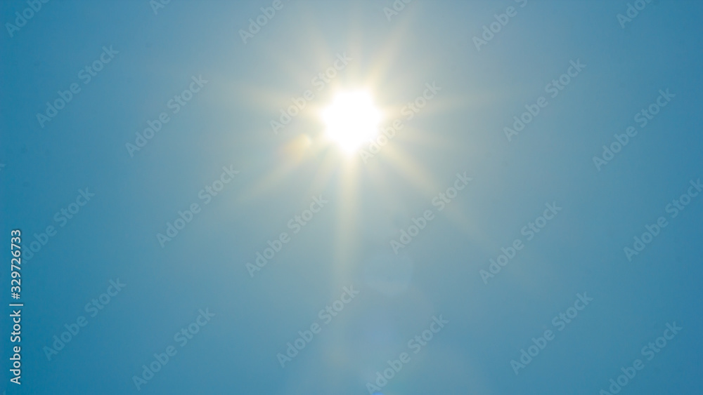 Shining sun at clear blue sky with copy space Shining sun at clear blue sky with copy space