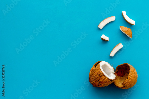 Coconuts frame - halfs and scattered pieces - on blue background top-down copy space © 9dreamstudio