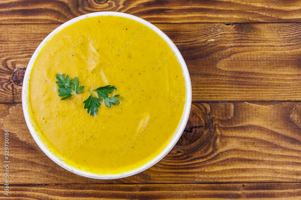 Pumpkin soup on a wooden table. Top view Pumpkin soup on a wooden table. Top view
