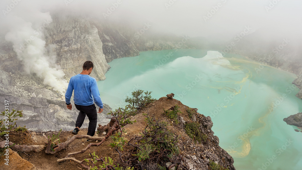 Man goes on the trail ijen smoke sulfuric acid lake Indonesia the island of Java Man goes on the trail ijen smoke sulfuric acid lake Indonesia the island of Java
