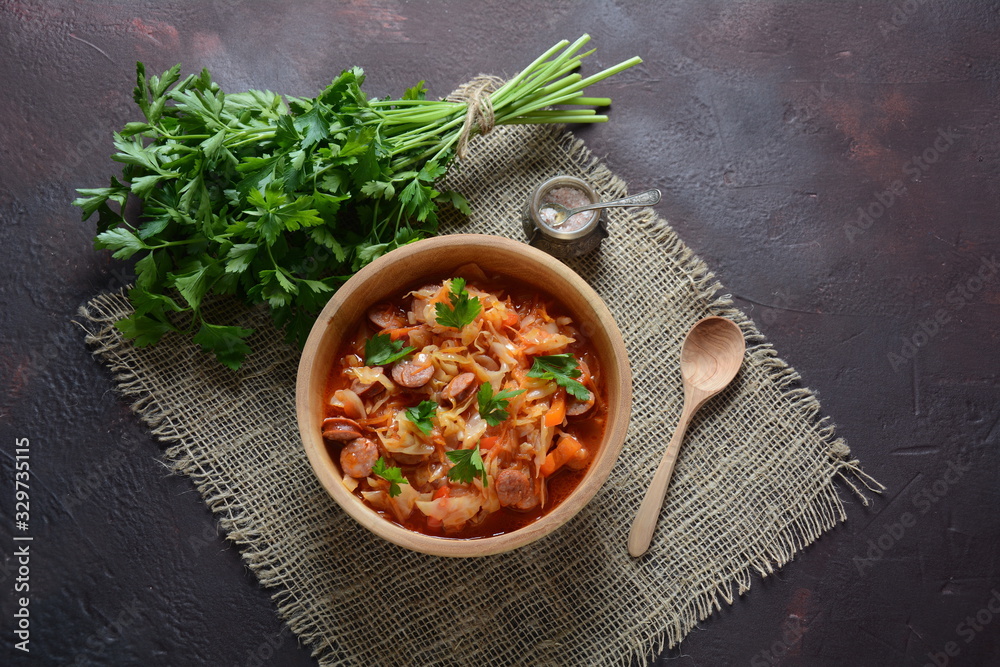 Cabbage stew with grilled sausage in tomato sauce - traditional dish of German, Polish or Russian cuisine Cabbage stew with grilled sausage in tomato sauce - traditional dish of German, Polish or Russian cuisine