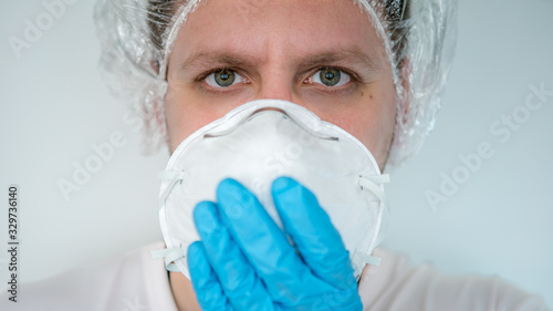 Man holding face mask. Protective raspiratory mask for spreading coronavirus photo