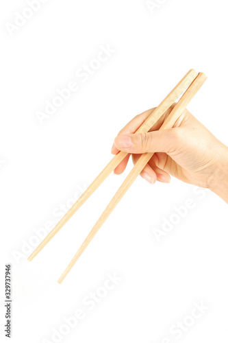 Hand holding bamboo chopsticks isolated on white