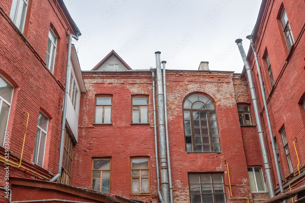 old red brick building with a rainwater drainage pipe