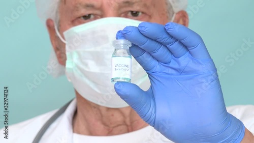 Elderly specialist showing vaccine for Coronavirus. Old physician vaccinating medicine remedy against Sars-CoV-2 infectious sickness, offering epidemic Covid-19 medical treatment
