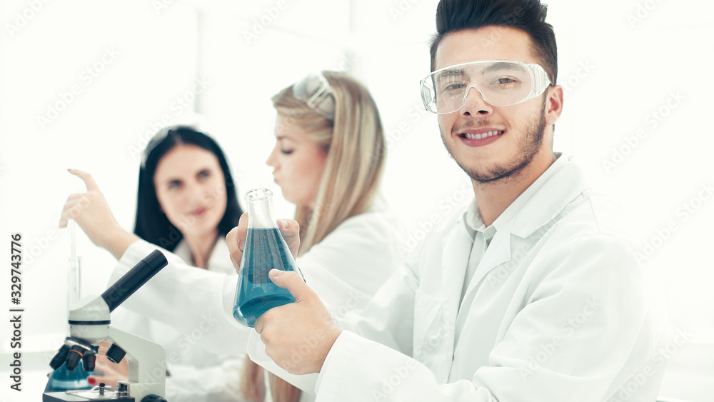 man scientist holding a flask of liquid for the experiment man scientist holding a flask of liquid for the experiment