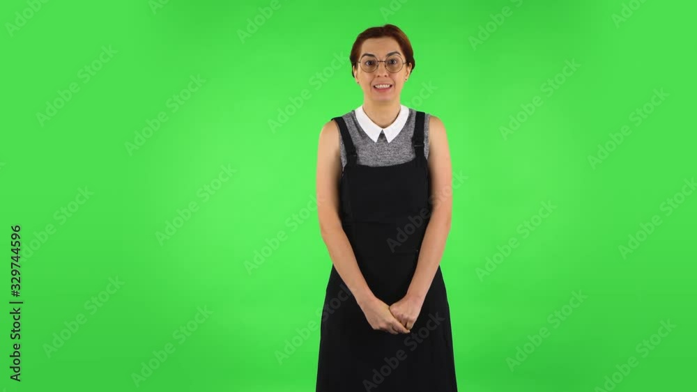 Funny girl in round glasses is talking about something then making a hush gesture, secret. Green screen Funny girl in round glasses is talking about something then making a hush gesture, secret. Green screen