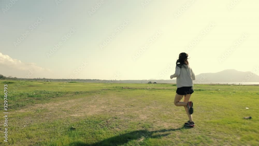 Young asian woman runner athlete jogging exercising workout outdoors at sunset fitness and healthy lifestyle concept. Young asian woman runner athlete jogging exercising workout outdoors at sunset fitness and healthy lifestyle concept.