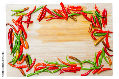 top view of green and red chilli on wood board, chilli frame