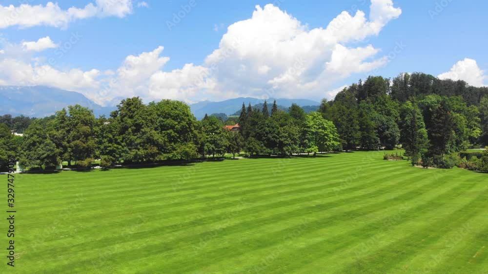 Medium Wide angle Dolly in Drone Shot of well maintained lawn and surrounding trees in Volcji Potok Arboretum during the day Medium Wide angle Dolly in Drone Shot of well maintained lawn and surrounding trees in Volcji Potok Arboretum during the day