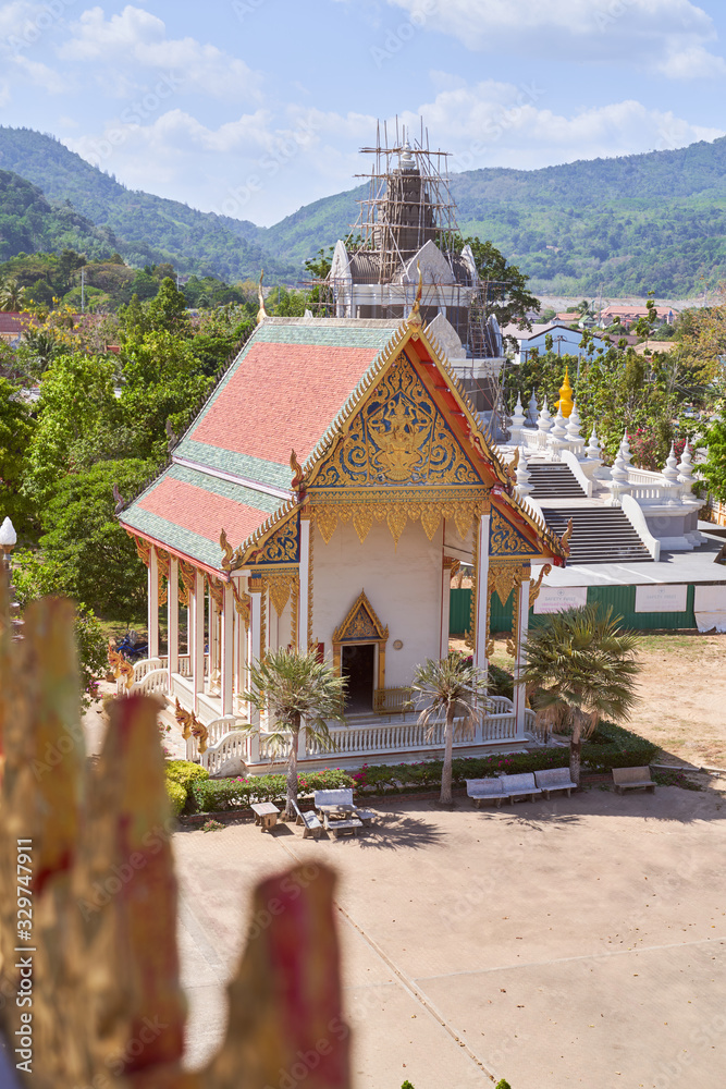 Wat Chalong or Chayatararam is Buddhist temple complex on island of Phuket in country of Thailand. Photo taken on February 23, 2020. building Pagoda decorated with gilt patterns, intricate carvings