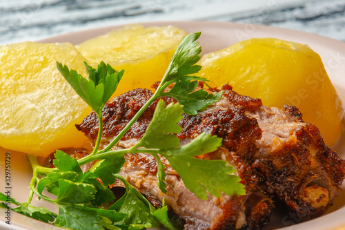 Juicy, baked pork ribs with new potatoes and herbs