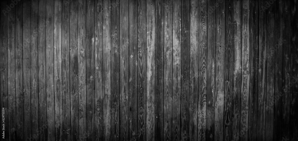 Black wooden board as background texture with dark vignetting .  