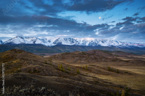 Morning in the Kurai steppe, the Moon over the North Chuysky ridge. Kosh-Agachsky District, Altai Republic, Russia