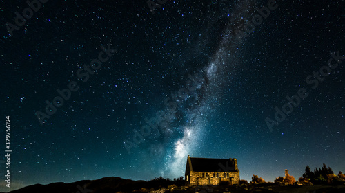 Backgrounds night sky with stars and milky way over the church at tekapo lake south island new zealand photo