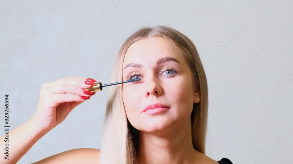 Eye Makeup. Beautiful Woman Applying Mascara On Lashes. Smiling Female Making Eyelashes Make-Up With Brush. Eye Makeup. Beautiful Woman Applying Mascara On Lashes. Smiling Female Making Eyelashes Make-Up With Brush.