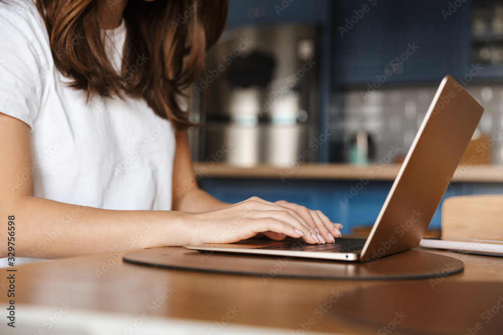 Cropped image of young woman typing on laptop Cropped image of young woman typing on laptop