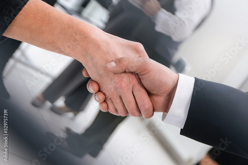 close up. businesswoman shaking hands with her business partner. © yurolaitsalbert