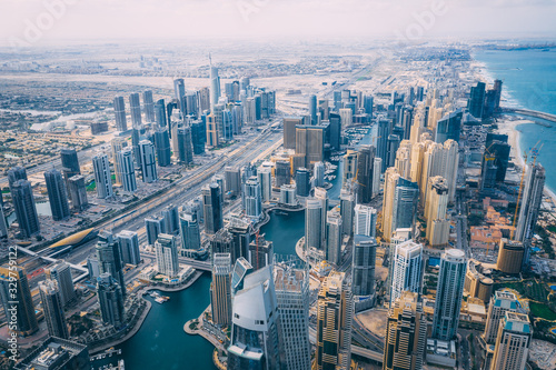 Fototapeta Naklejka Na Ścianę i Meble -  Aerial view of High rise buildings and futuristic architecture of Dubai Marina with man made lake flowing through