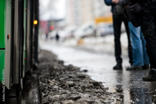 Wallpaper Mural people are standing at a bus stop, getting on a bus stepping over uncleared snow and mud, special services do not clean the city Torontodigital.ca