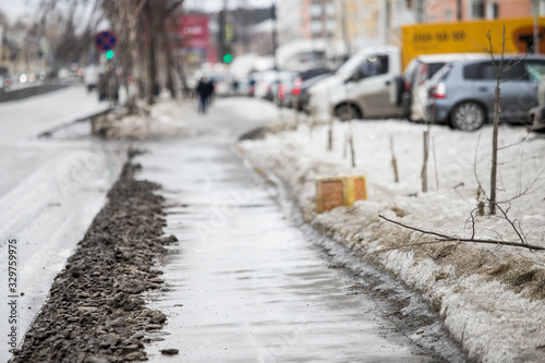 Road pits in the city in the spring after the snow melts. Problem of roads and asphalt in the city. © Семен Саливанчук